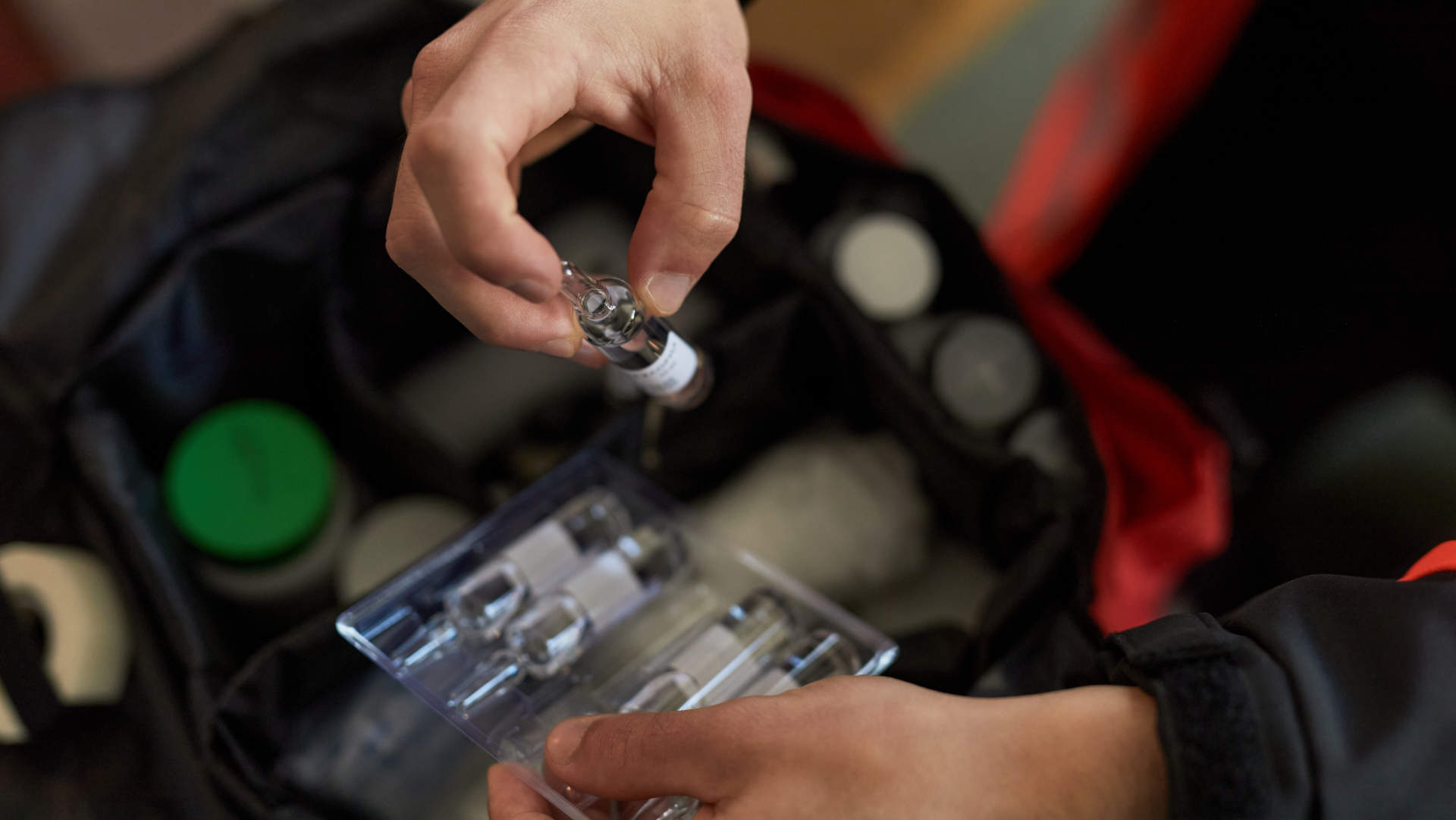 Ampoule of adrenaline being lifted from a drug tray